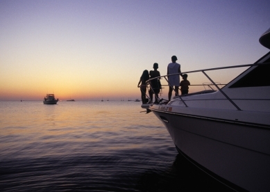 Family looking at sunset from boat's prow